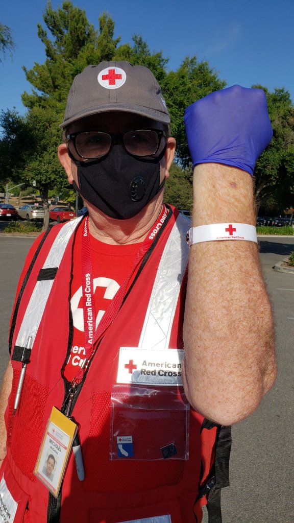 Red Cross volunteer Michael M. shows his wrist band that he received after completing his health screening.